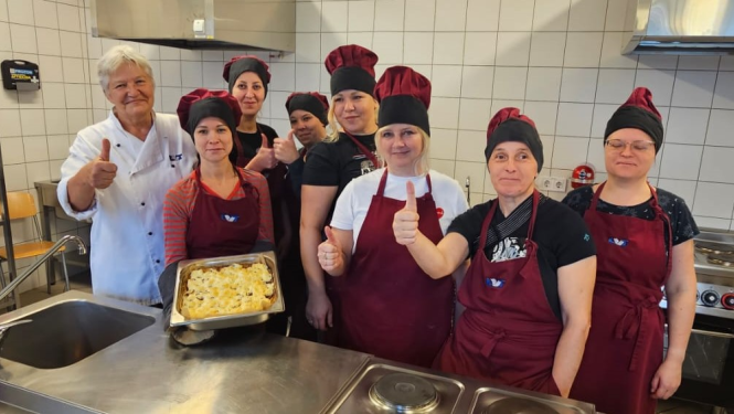 Kopbilde ar dalībniekiem — pavāra tērpos un ar skolotāju